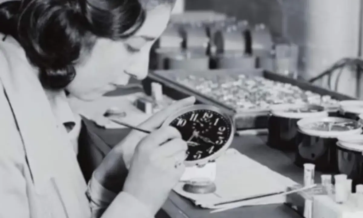 Eine junge Frau malt Zifferblätter, eine der vielen "Radium Girls", die mit leuchtender Farbe arbeiteten.