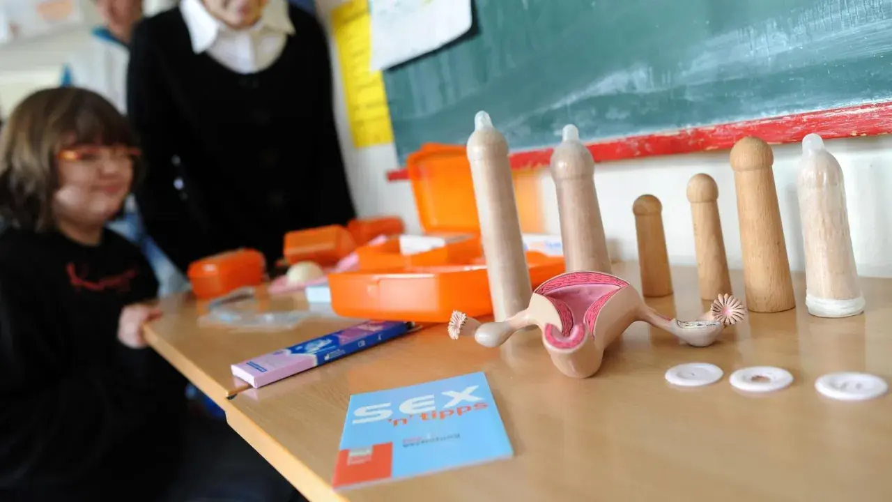 Modelle für Sexualkunde Klasse 6: Anatomie, Kondome und Aufklärungsmaterialien auf einem Tisch.