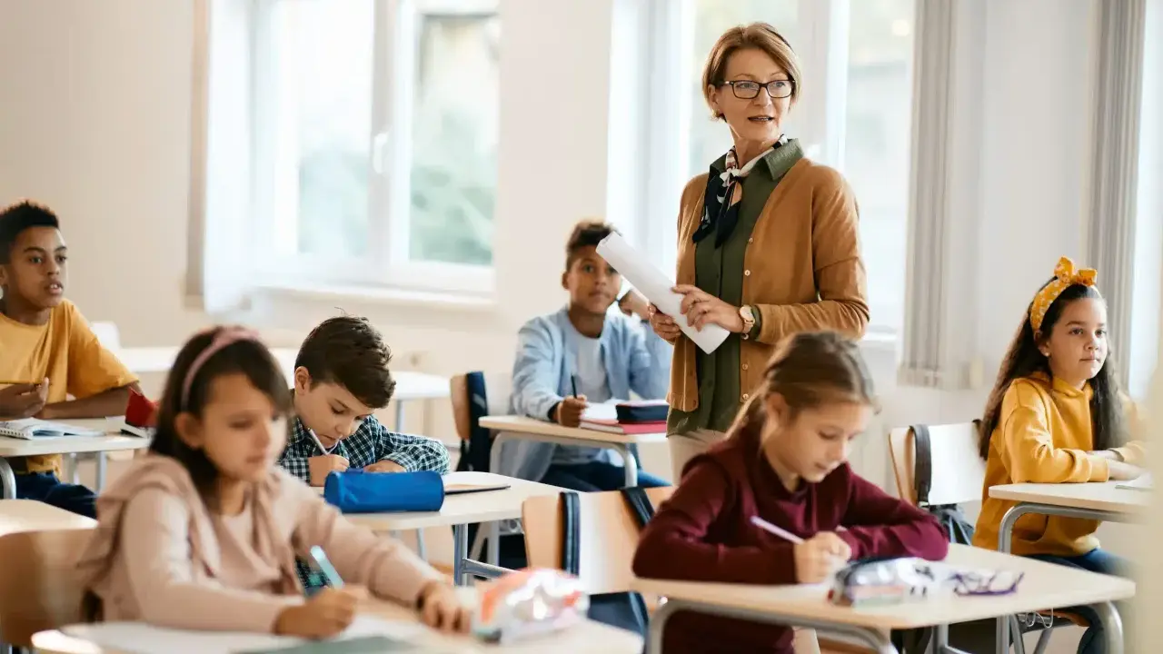 Lehrerin erklärt den Schülern im Klassenzimmer, wie sie eine ausreichend note erreichen.