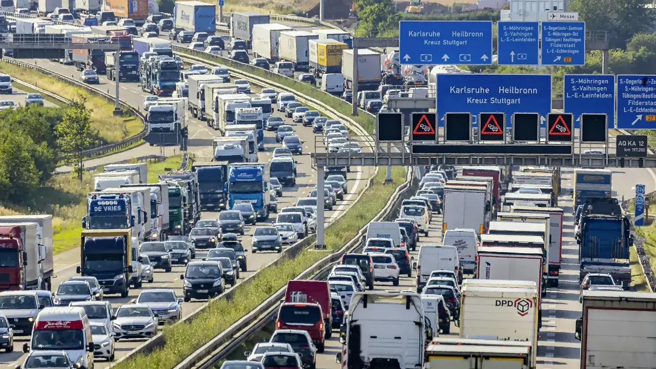 Stau auf der Autobahn. Viele Autos und LKW stecken fest. Welches Bundesland hat als erstes Sommerferien? Die Antwort ist nicht im Bild zu sehen.
