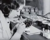 Eine junge Frau malt Zifferblätter, eine der vielen "Radium Girls", die mit leuchtender Farbe arbeiteten.