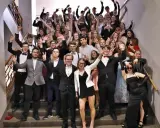 Schüler feiern Mottowoche Filme und Serien auf einer Treppe, alle in schicken Outfits, viele mit V-Gesten.