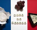 Französische Flagge mit Käse, Trauben und Scrabble-Buchstaben "VIVE LA FRANCE".