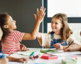 Kinder geben sich beim Lernen die Hand. Sie arbeiten an verschiedenen **Gruppenarbeit Methoden** und zeigen Freude am gemeinsamen Erfolg.