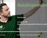 Mann erklärt "Relativpronomen" auf einer Tafel. Deutsche Grammatik.