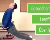 Mann macht eine Rückbeuge über einem Schreibtisch. Gesundheit und Lernen werden durch diese Bewegungsspiele gefördert. Über 300 Videos verfügbar.