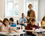 Lehrerin erklärt den Schülern im Klassenzimmer, wie sie eine ausreichend note erreichen.