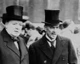 Winston Churchill und Neville Chamberlain, die die Appeasement-Politik kritisierten, tragen Zylinder.