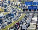 Stau auf der Autobahn. Viele Autos und LKW stecken fest. Welches Bundesland hat als erstes Sommerferien? Die Antwort ist nicht im Bild zu sehen.