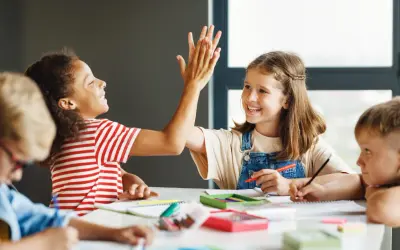 Kinder geben sich beim Lernen die Hand. Sie arbeiten an verschiedenen **Gruppenarbeit Methoden** und zeigen Freude am gemeinsamen Erfolg.