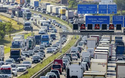 Stau auf der Autobahn. Viele Autos und LKW stecken fest. Welches Bundesland hat als erstes Sommerferien? Die Antwort ist nicht im Bild zu sehen.