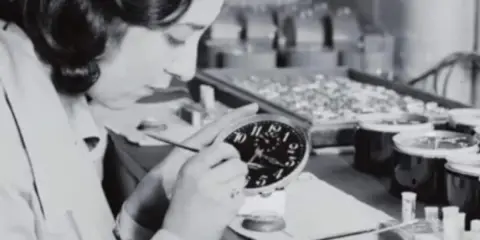 Eine junge Frau malt Zifferblätter, eine der vielen "Radium Girls", die mit leuchtender Farbe arbeiteten.