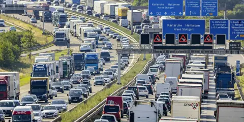 Stau auf der Autobahn. Viele Autos und LKW stecken fest. Welches Bundesland hat als erstes Sommerferien? Die Antwort ist nicht im Bild zu sehen.