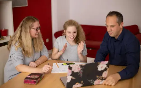 Familie lernt gemeinsam. Die Tochter freut sich über Fortschritte. Nachhilfe Preise pro Stunde sind hier gut investiert.