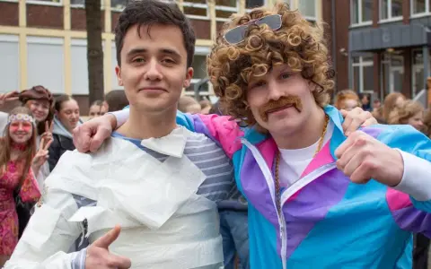 Zwei Schüler feiern die zeitreise mottowoche. Einer ist in Klopapier gewickelt, der andere trägt eine Perücke und einen Schnurrbart.