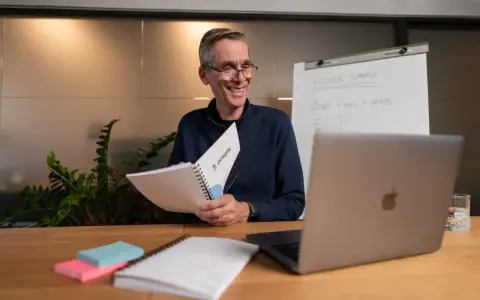 Lehrer erklärt **adjektive und adverbien englisch** mit einem Flipchart und Notizbuch.