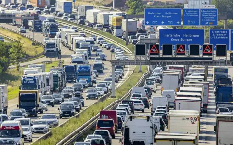 Stau auf der Autobahn. Viele Autos und LKW stecken fest. Welches Bundesland hat als erstes Sommerferien? Die Antwort ist nicht im Bild zu sehen.