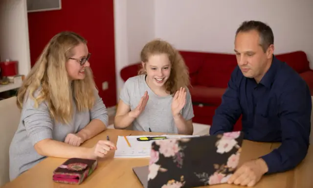 Familie lernt gemeinsam. Die Tochter freut sich über Fortschritte. Nachhilfe Preise pro Stunde sind hier gut investiert.