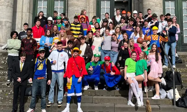 Schüler feiern Mottowoche in bunten Kostümen, darunter Super Mario und ein Pirat.