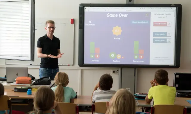 Lehrer präsentiert interaktive Spiele für Vertretungsstunden. Die Klasse spielt ein Quiz, das "Game Over" anzeigt.