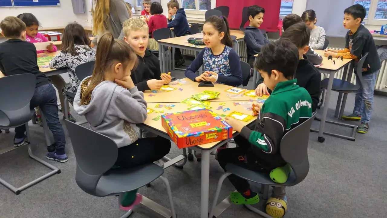 Kinder spielen konzentriert das Spiel Ubongo Junior. Diese Bewegungsspiele fördern das logische Denken und die Feinmotorik.
