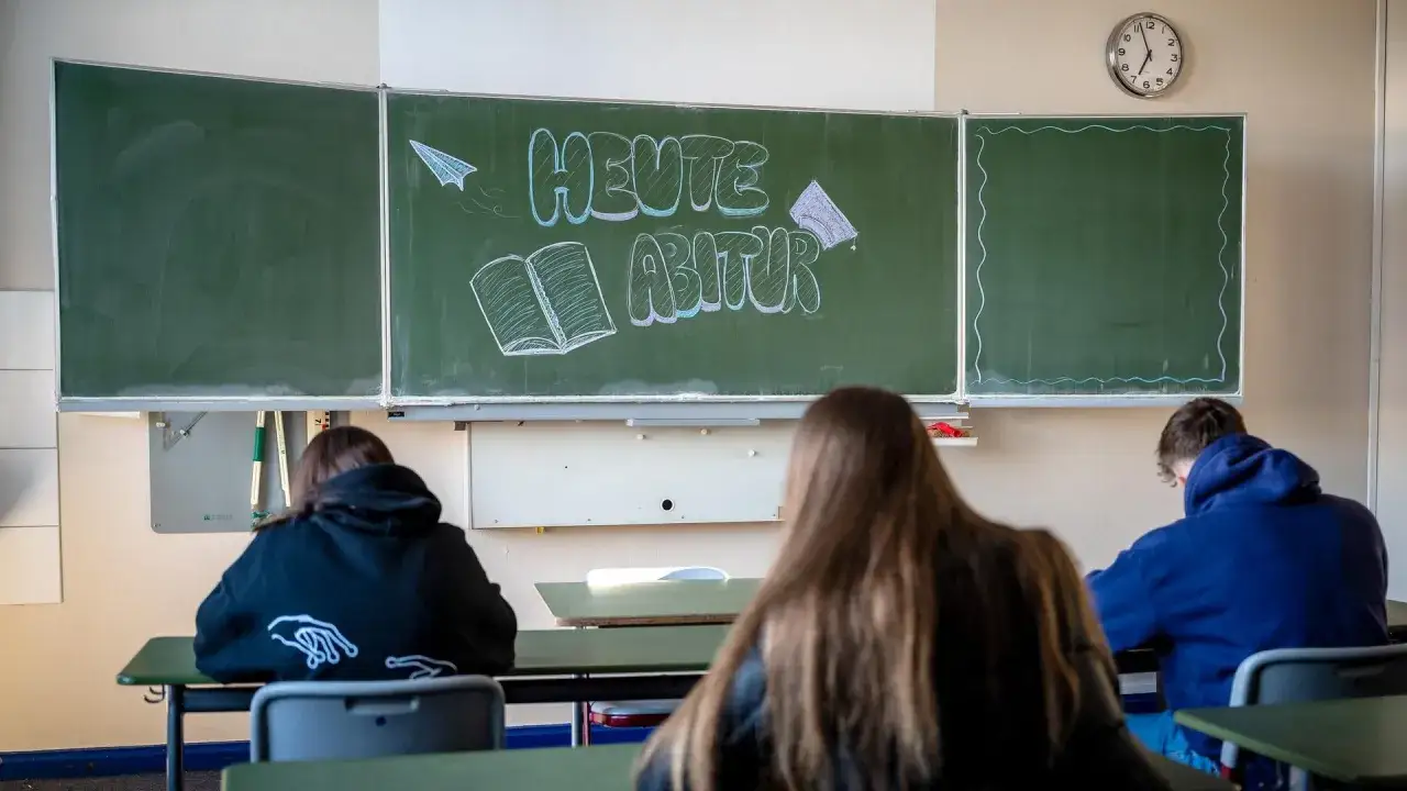 Schüler sitzen im Klassenzimmer, während auf der Tafel 