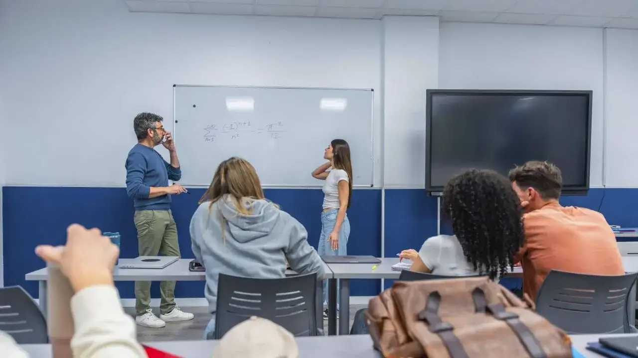 Lehrer erklären Mathe an der Tafel, während Schüler zuhören. Ob Lehrer Beamte sind, ist eine andere Frage.