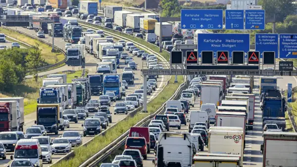 Stau auf der Autobahn. Viele Autos und LKW stecken fest. Welches Bundesland hat als erstes Sommerferien? Die Antwort ist nicht im Bild zu sehen.